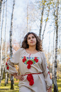 Portrait of woman standing by tree