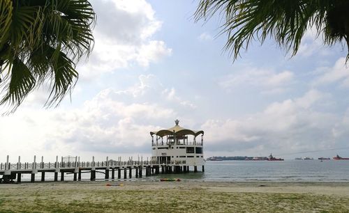 Built structure on beach by sea against sky