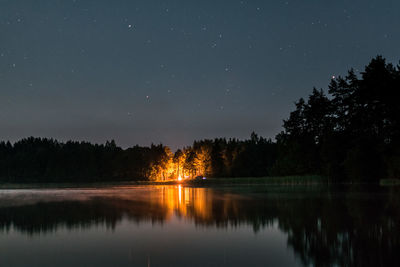 Scenic view of lake against sky at night