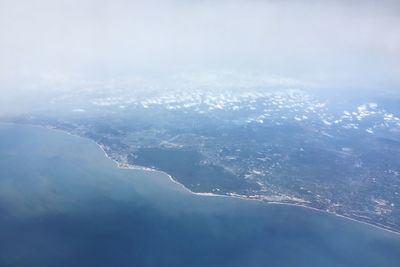 Aerial view of sea and mountains against sky