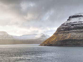 Scenic view of sea and mountains against sky