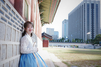 Portrait of young woman standing in city