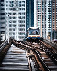 Railroad tracks amidst buildings in city