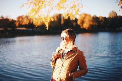 Full length of woman standing by lake