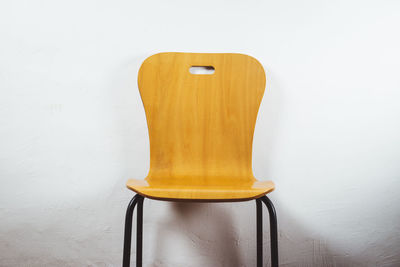 Close-up of yellow telephone on table against wall