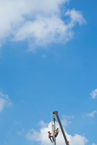 Low angle view of crane against blue sky