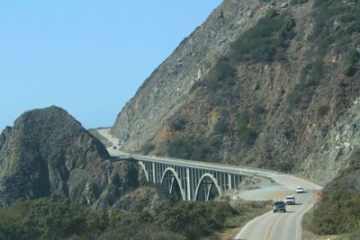 Bridge over mountain road against sky