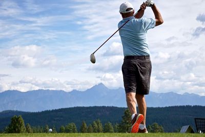 Rear view of man standing on golf course