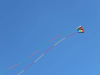 Low angle view of kite flying against clear blue sky