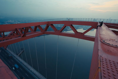 Bridge over river against cloudy sky