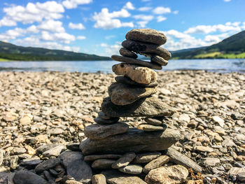 Stack of stones on beach against sky