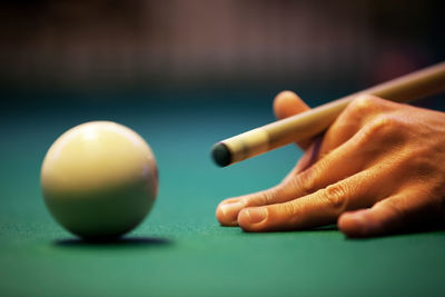 Cropped hand of man playing pool