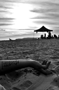 Close-up of person on beach against sky