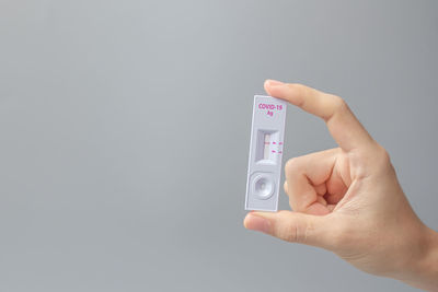 Close-up of person holding hands against white background