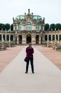 Rear view of woman standing in front of building