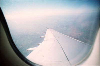 Airplane wing seen through glass window
