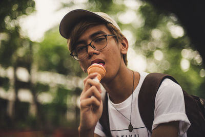 Portrait of young man holding eyeglasses