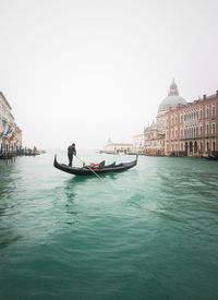 View of boats in canal against clear sky