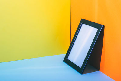 Low angle view of telephone on table against wall