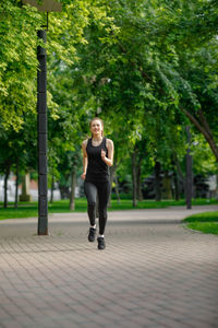 Portrait of young woman walking on road