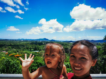 Portrait of happy mum and baby against sky