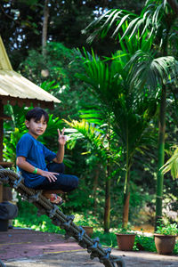 Portrait of boy gesturing while standing in park