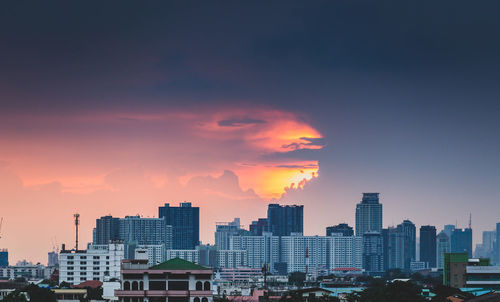 Buildings in city against sky during sunset