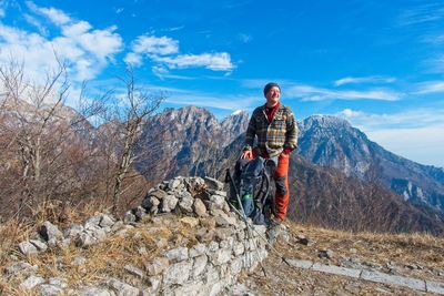 Full length of man standing on rock against sky