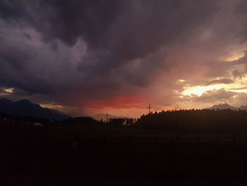 Silhouette landscape against dramatic sky during sunset