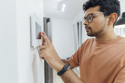 Man using smart home device on wall