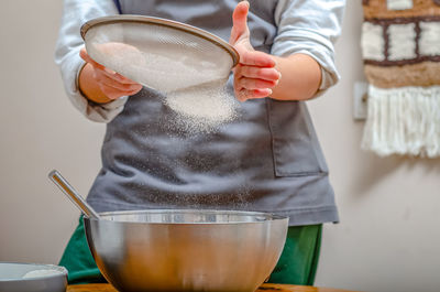 Cook sifts flour through sieve to make dough