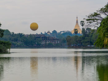 Scenic view of lake by buildings against sky