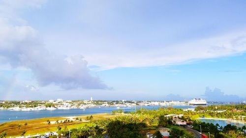 Scenic view of town by sea against sky