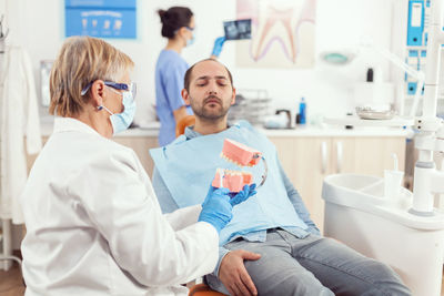 Dentist talking with patient at clinic