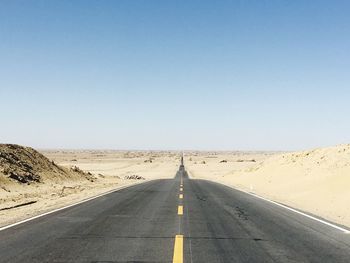 Road amidst dessert against clear sky