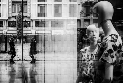 Side view of woman standing against store