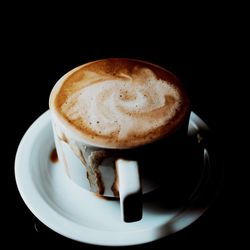 High angle view of coffee cup against black background