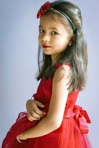 Portrait of smiling girl against gray background