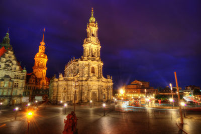 Illuminated buildings against sky at night