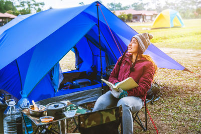 Rear view of woman sitting on tent