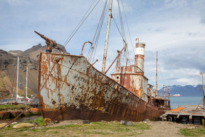 Abandoned ship in sea against sky