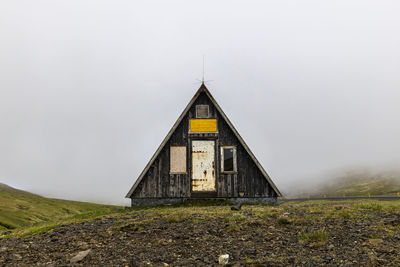 House on field against clear sky
