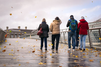 Rear view of people on water against sky