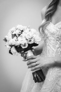 Midsection of woman with bouquet