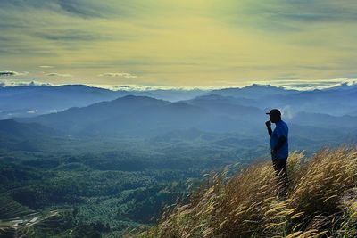 Man standing on mountain against sky