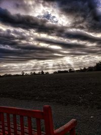 Scenic view of field against cloudy sky during sunset