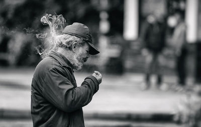 Side view of woman smoking outdoors