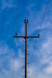 Low angle view of electricity pylon against sky