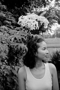 Young woman holding flower in park