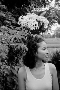 Young woman holding flower in park